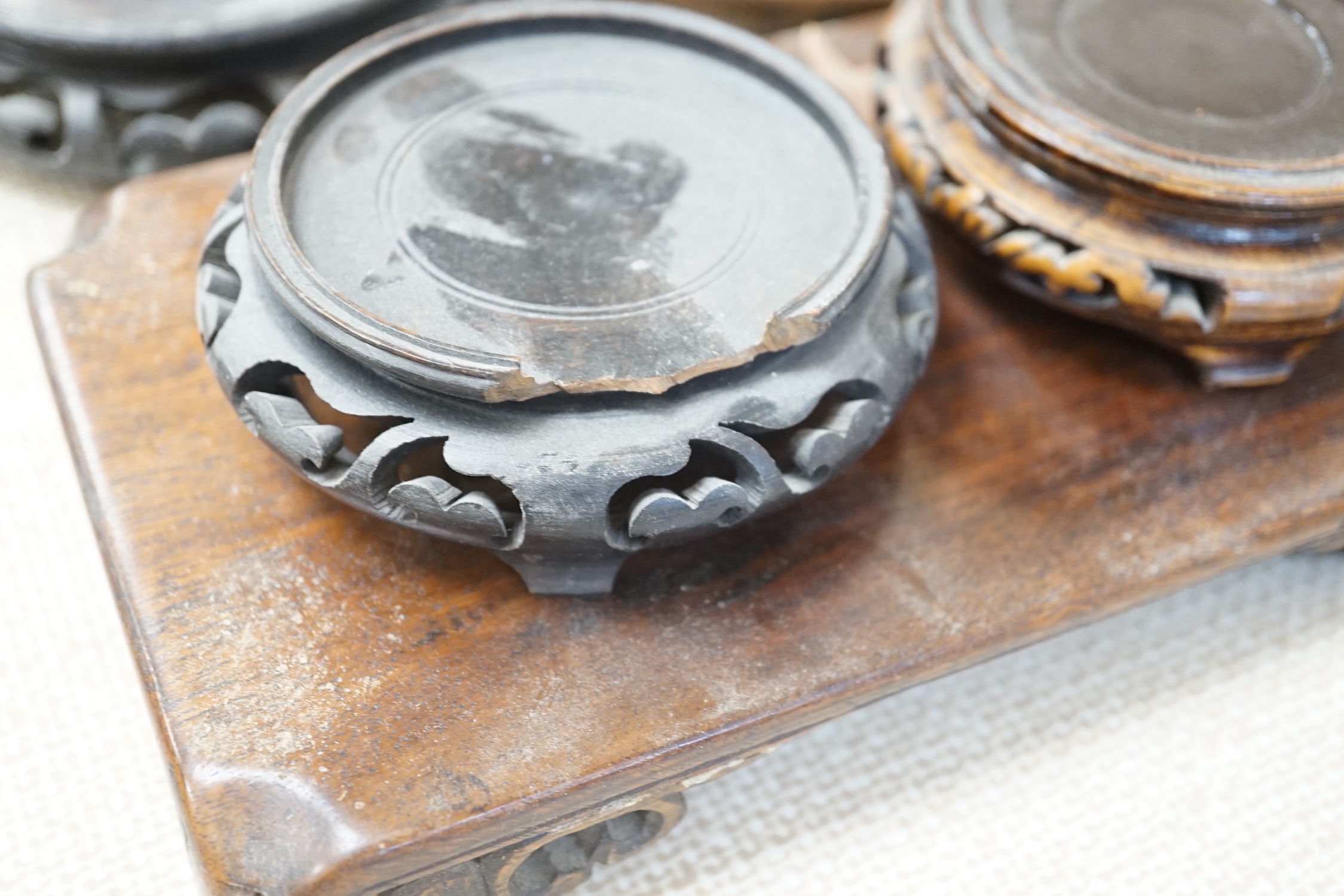 Seventeen Chinese carved wood stands of varying sizes, largest 30cm diameter